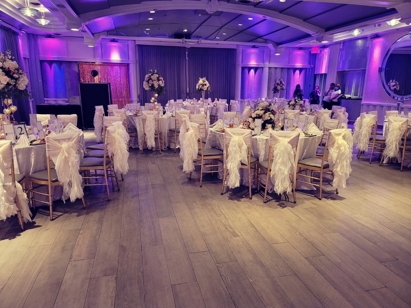 indoor wedding reception with purple uplighting