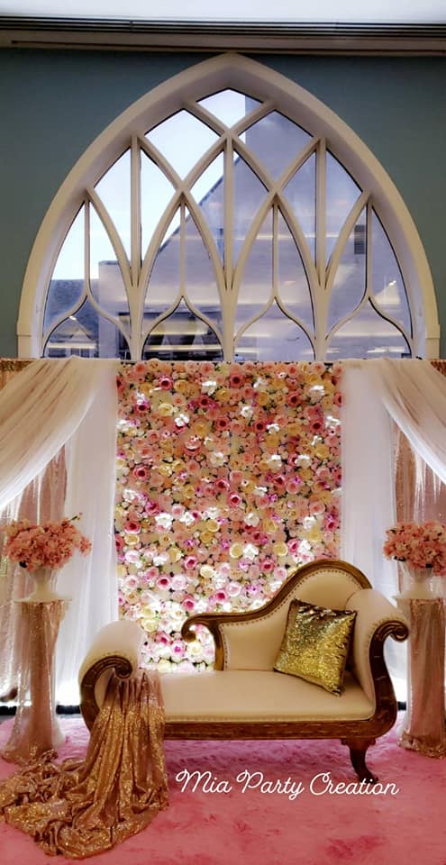 white and pink floral backdrop behind antique couch