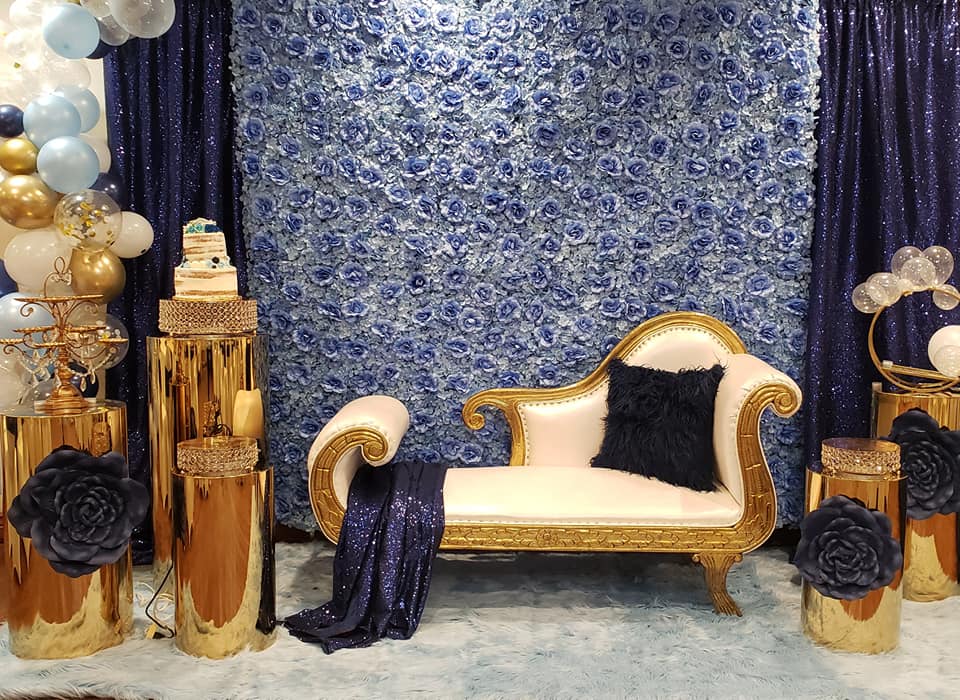 blue floral photo backdrop behind white and gold couch