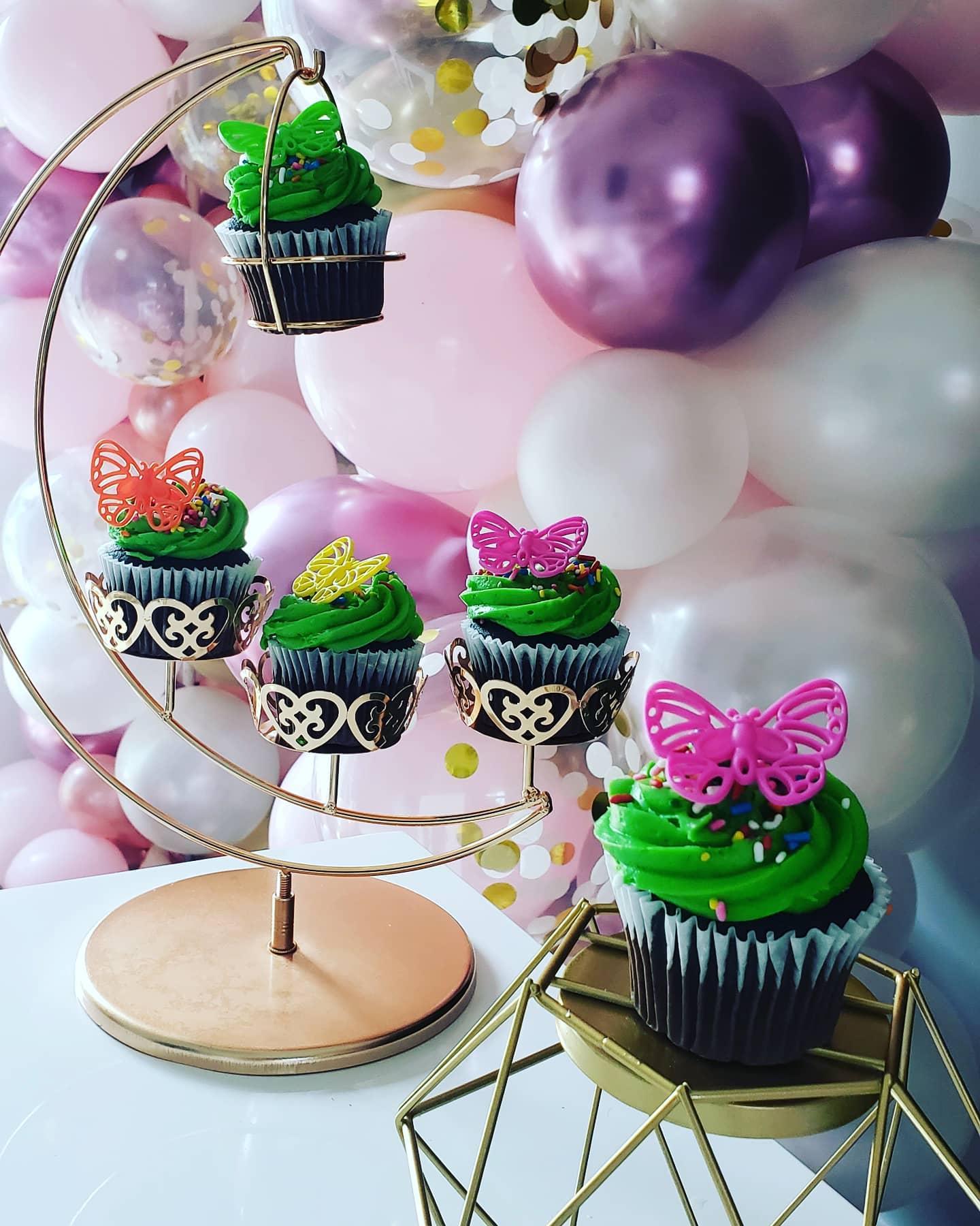 cupcakes in front of balloon backdrop